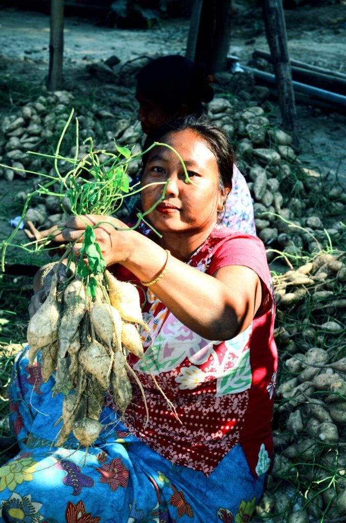 A woman from the hilly tracts of Bangladesh proudly displays freshly harvested organic vegetables in a basket.